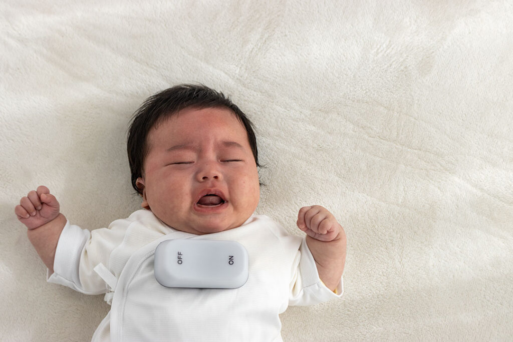 泣いている赤ちゃんと、背中スイッチイメージ